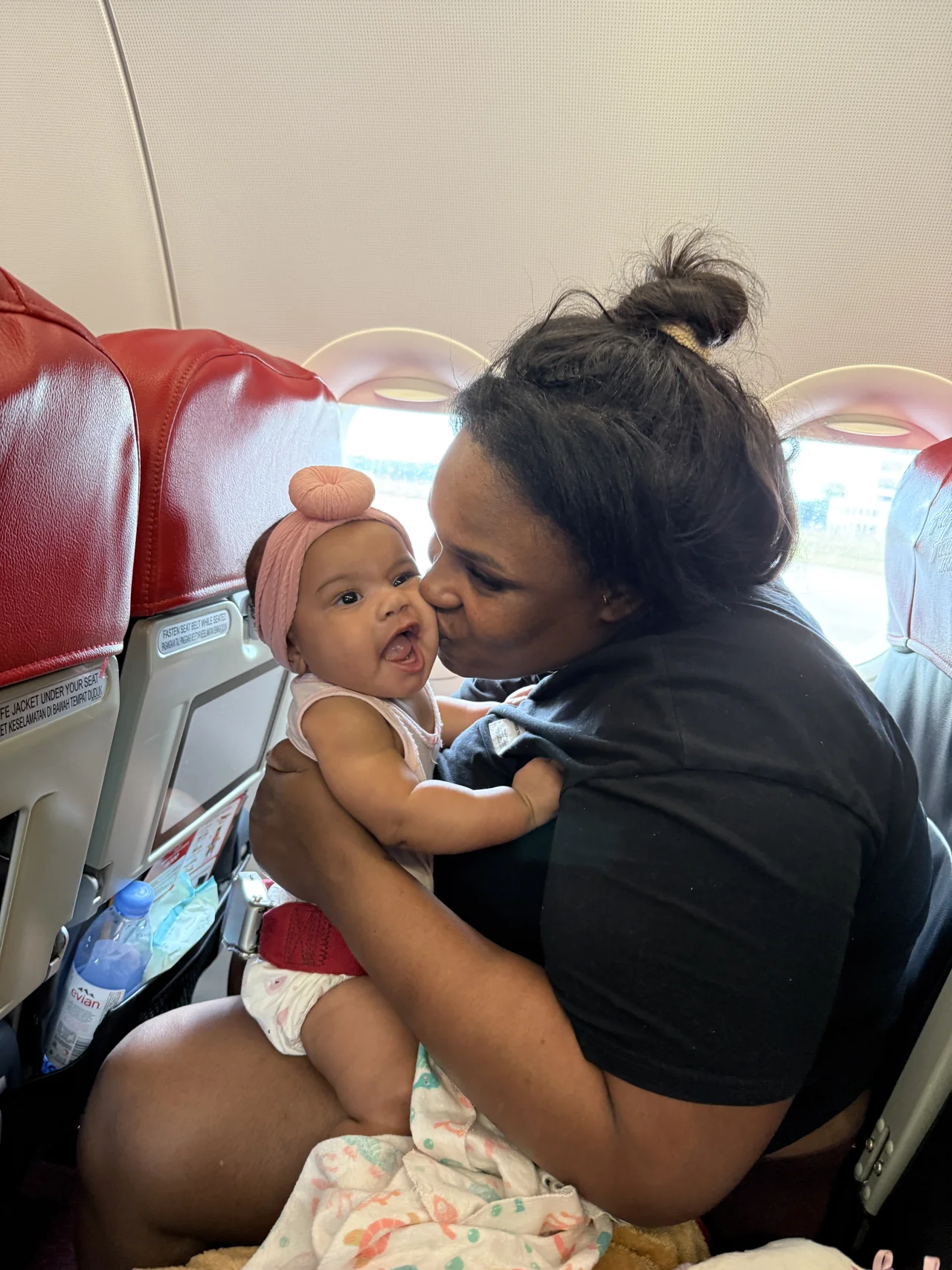 Amia and her smiling baby on a plane